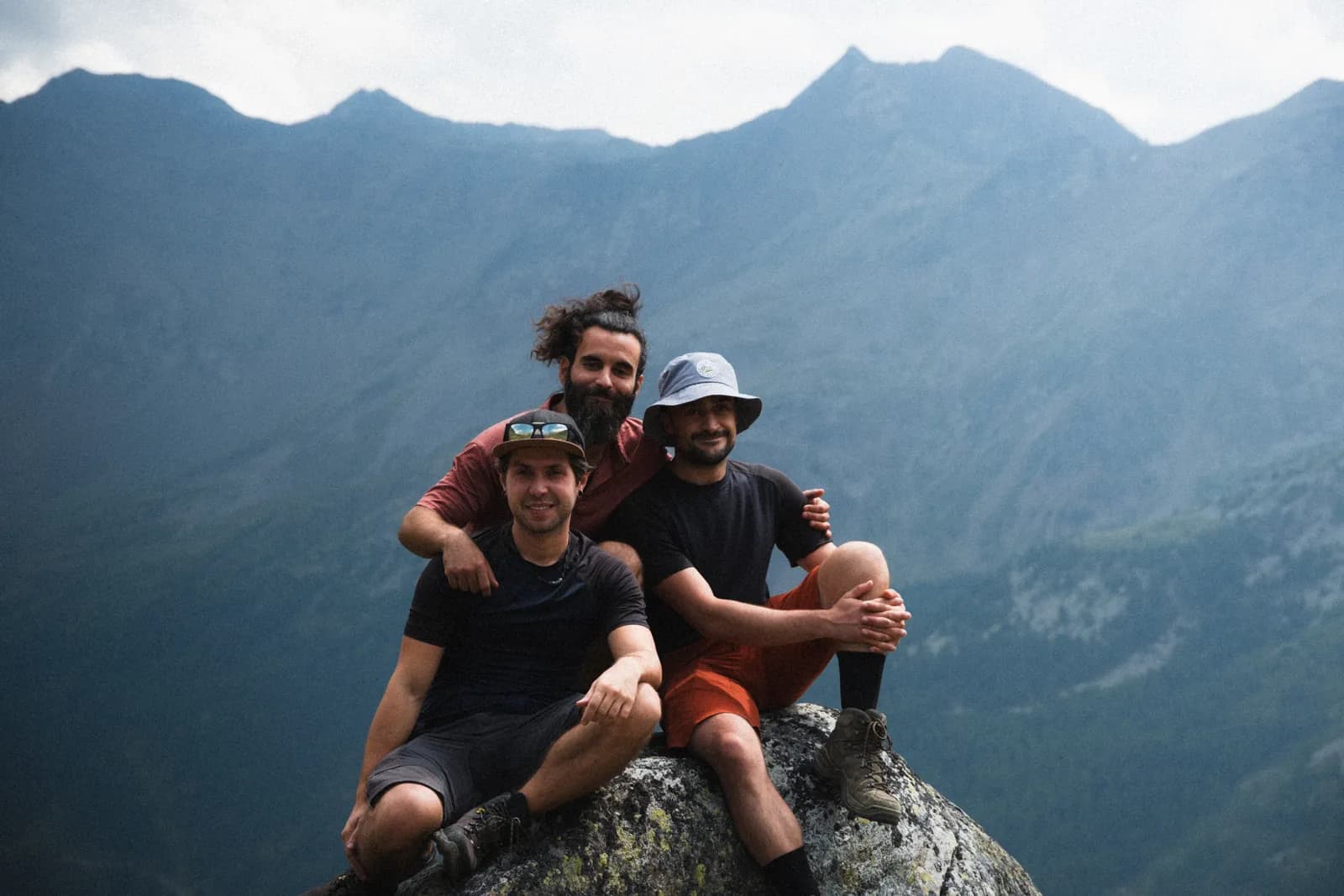 I tre ragazzi di Ludotech Studio, seduti su una roccia in montagna
